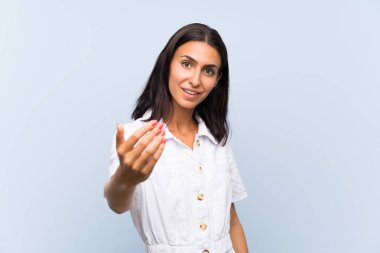 Izole mavi arka plan üzerinde genç kadın gelmeye davet