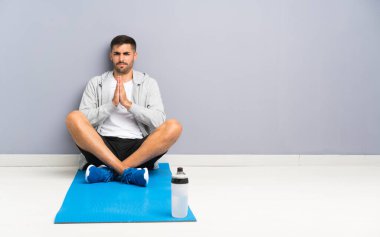 Spor adamı yerde oturmuş yalvarıyor.