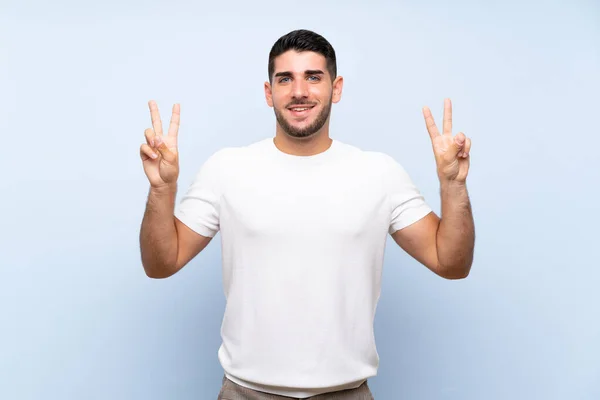 Hombre Guapo Caucásico Sobre Fondo Azul Aislado Mostrando Signo Victoria —  Fotos de Stock