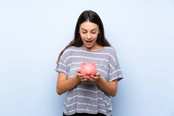 Mladá Brunetka Žena Izolovaném Modrém Pozadí Velkou Piggyovou Bankou — Stock fotografie