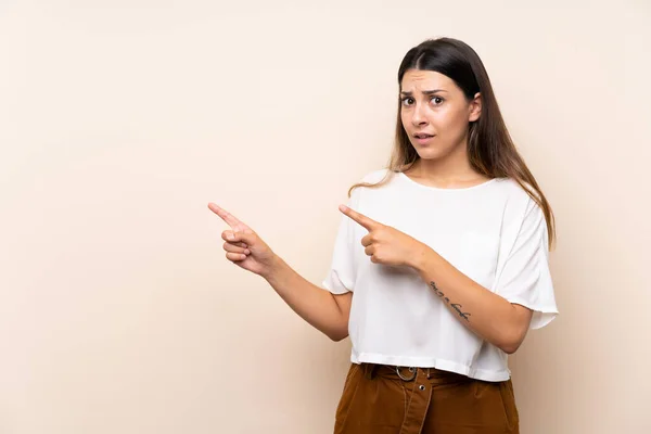 Giovane Donna Bruna Sfondo Isolato Spaventata Indicando Lato — Foto Stock