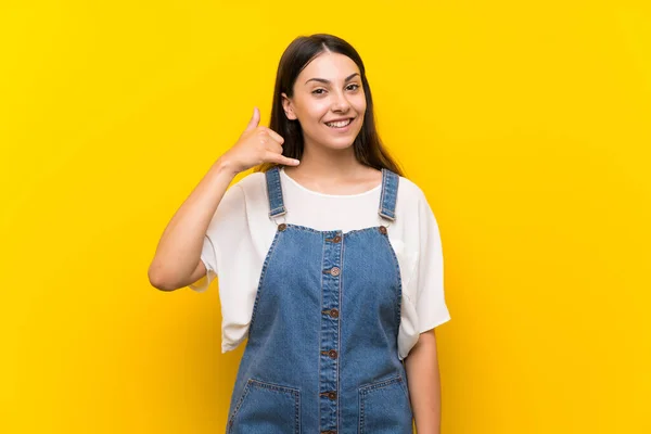 Jonge Vrouw Dungarees Geïsoleerde Gele Achtergrond Maakt Telefoon Gebaar Bel — Stockfoto