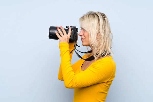 Ung Blond Kvinna Över Isolerad Bakgrund Med Professionell Kamera — Stockfoto