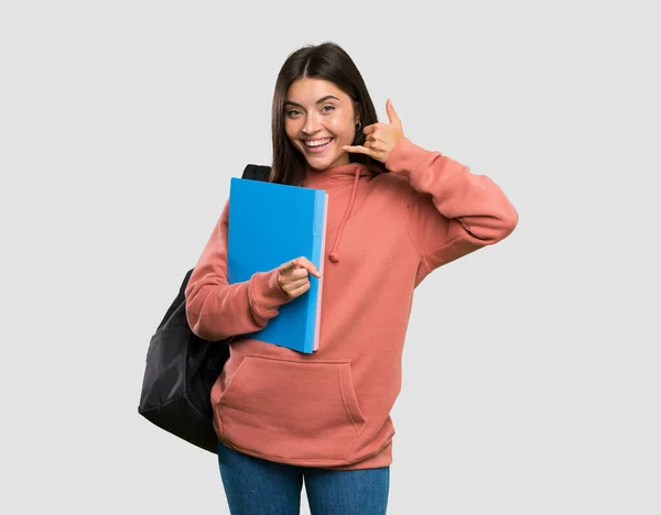 Jovem Estudante Mulher Segurando Cadernos Fazendo Gesto Telefone Apontando Frente — Fotografia de Stock