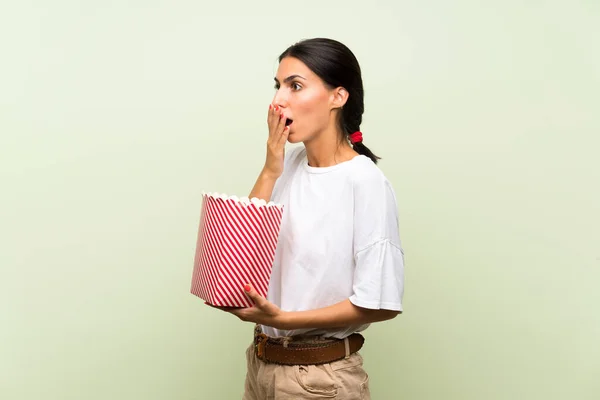 Mujer Joven Sobre Fondo Verde Aislado Sosteniendo Tazón Palomitas Maíz — Foto de Stock