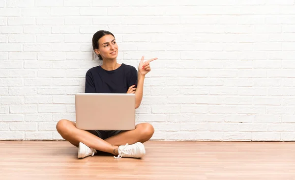 Νεαρή Γυναίκα Ένα Φορητό Υπολογιστή Που Κάθεται Στο Πάτωμα Δείχνοντας — Φωτογραφία Αρχείου