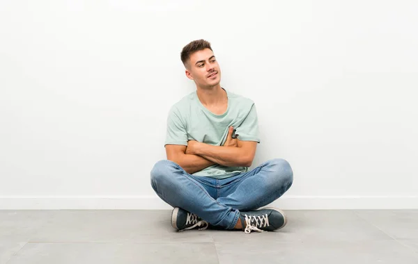 Mladý Pohledný Muž Sedí Podlaze Směje — Stock fotografie