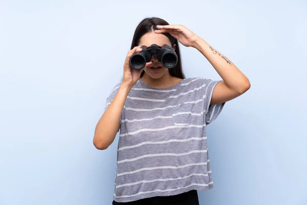 Joven Morena Sobre Fondo Azul Aislado Con Binoculares Negros —  Fotos de Stock