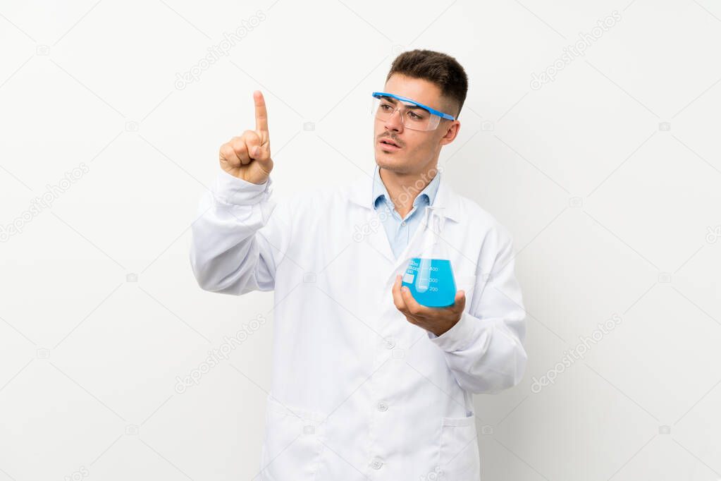 Young scientific holding laboratory flask over isolated background touching on transparent screen