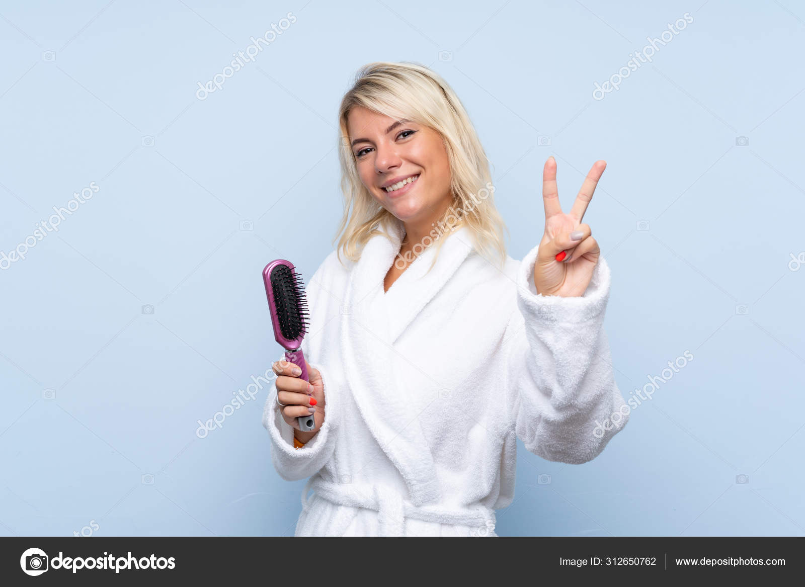 Mujer Joven Albornoz Sonriendo Mostrando Signo Victoria: fotografía de stock © luismolinero #312650762 | Depositphotos