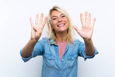 İzole edilmiş beyaz arka planda genç sarışın kadın parmaklarıyla dokuz sayıyor.