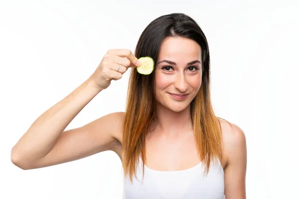 Mooie jonge vrouw houdt plakjes komkommer over geïsoleerde witte achtergrond — Stockfoto