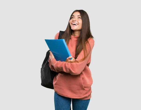 Joven Estudiante Sosteniendo Cuadernos Mirando Hacia Arriba Mientras Sonríe Sobre —  Fotos de Stock