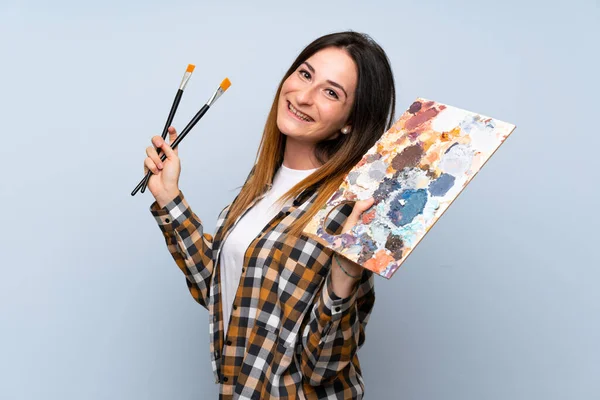 Młoda kobieta malarz na białym tle niebieskim — Zdjęcie stockowe