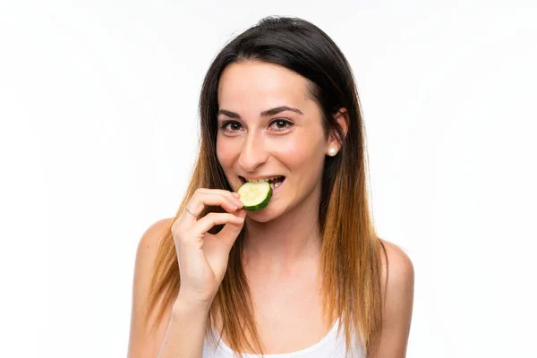 Mooie jonge vrouw houdt plakjes komkommer over geïsoleerde witte achtergrond — Stockfoto