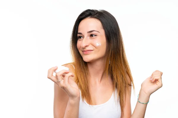 Jonge vrouw met moisturizer over geïsoleerde witte achtergrond — Stockfoto