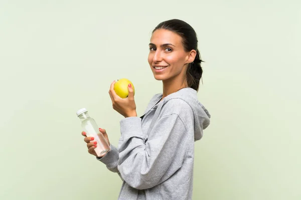 Jonge Sportvrouw met een appel en een flesje Const — Stockfoto