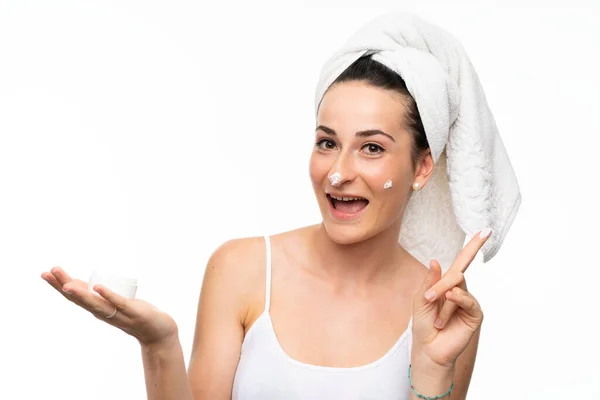 Jeune femme avec hydratant sur fond blanc isolé — Photo