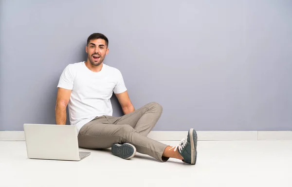 Joven Con Portátil Sentado Suelo Con Expresión Facial Sorpresa — Foto de Stock