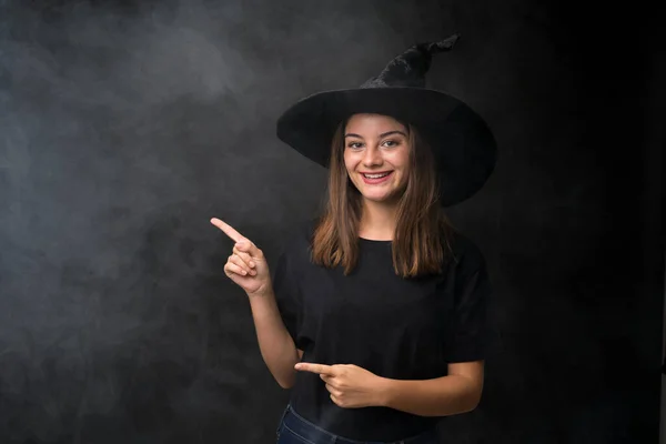 Girl Witch Costume Halloween Parties Isolated Dark Background Pointing Finger — Stock Photo, Image
