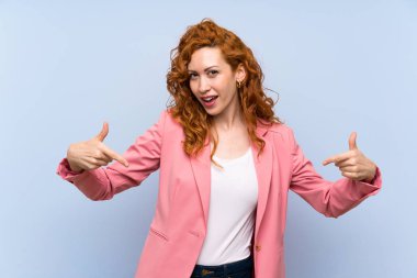 Kırmızı elbiseli kadın mavi duvarın üstünde gururlu ve kendini beğenmiş.