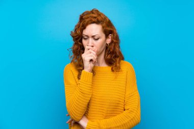 Redhead woman with yellow sweater is suffering with cough and feeling bad
