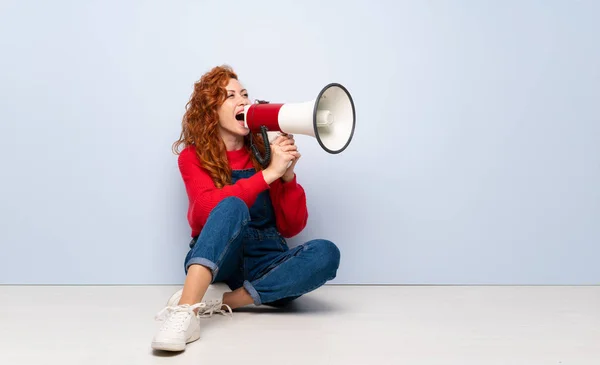 Redhead Vrouw Met Overalls Zittend Vloer Schreeuwen Door Een Megafoon — Stockfoto