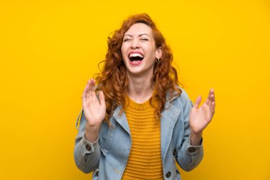Izole sarı arka plan üzerinde Redhead kadın gülüyor