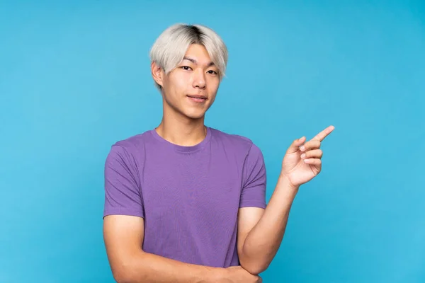 Young Asian Man Isolated Blue Background Pointing Finger Side — Φωτογραφία Αρχείου