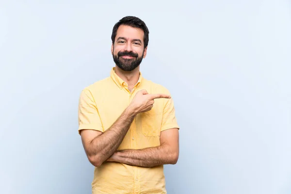 Jeune Homme Avec Barbe Sur Fond Bleu Isolé Pointant Doigt — Photo