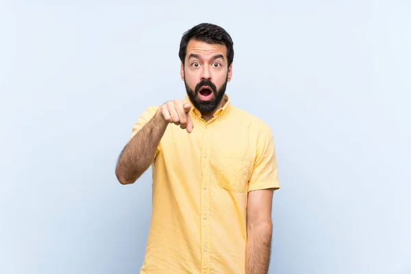 Jeune Homme Avec Barbe Sur Fond Bleu Isolé Surpris Pointant — Photo