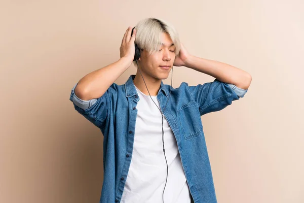 Joven Asiático Hombre Sobre Aislado Fondo Usando Móvil Con Auriculares — Foto de Stock
