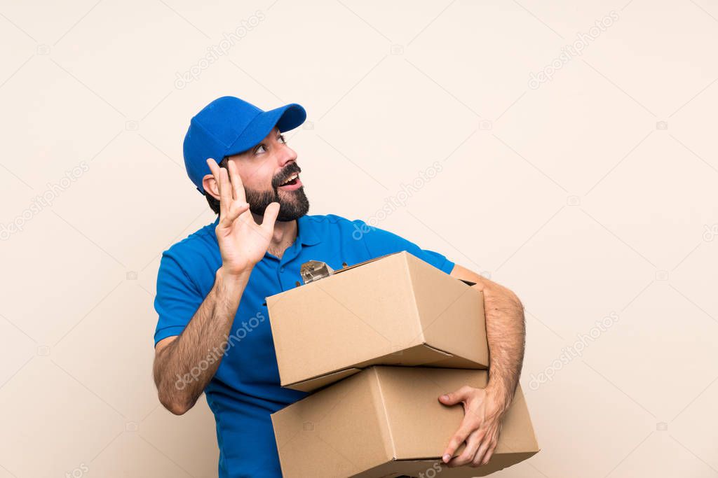 Delivery man with beard over isolated background nervous and scared