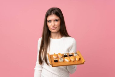 Sushi 'si olan genç bir kız soyutlanmış pembe bir geçmişi ve üzgün bir ifadesi var.
