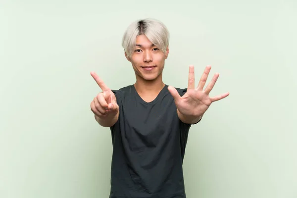 Mladý Asijský Muž Přes Izolované Zelené Pozadí Počítání Šest Prsty — Stock fotografie