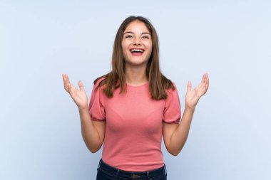 Genç esmer kız soyutlanmış mavi arka planda gülüyor.