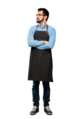 İzole edilmiş beyaz arkaplan üzerinde yüz ifadesini karıştıran önlüklü adamın tam boy görüntüsü