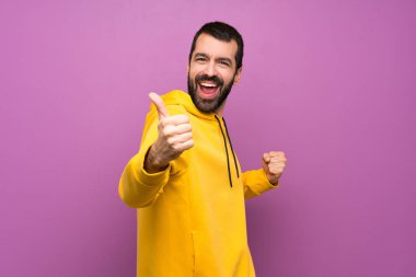 Güzel bir şey olduğu için sarı kazaklı yakışıklı bir adam.