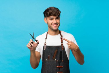 Genç yakışıklı, soyutlanmış, mavi bir geçmişi var. Kuaför ya da berber elbisesi var ve onu işaret ediyor.