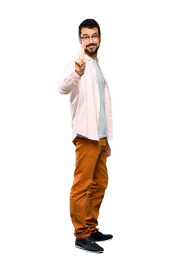 Sakallı, yakışıklı bir adamın izole edilmiş beyaz arka planda parmağını kaldırırken tam boy fotoğrafı.