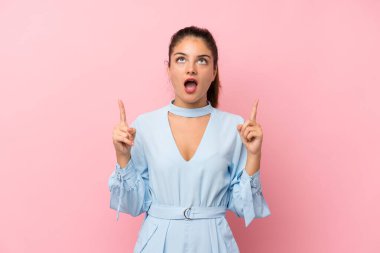 İzole edilmiş pembe arka planda genç esmer kız işaret parmağıyla işaret etmek harika bir fikir.