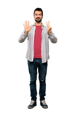 Sakallı yakışıklı bir adam, yediyi sayıyor ve parmakları izole edilmiş beyaz arka planda.