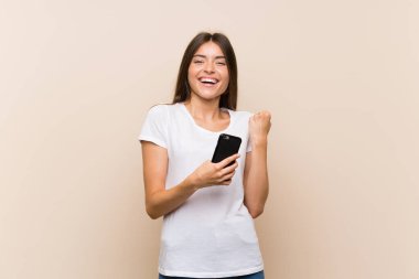 Galibiyet pozisyonunda telefonla izole edilmiş güzel bir genç kız.