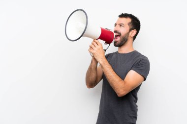 Soyutlanmış beyaz arka planda genç yakışıklı bir adam megafondan bağırıyor.