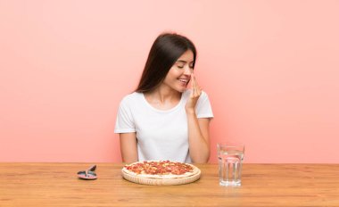 Pizzalı genç bir kadın, çok gülümsüyor.