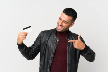 Soyutlanmış beyaz bir geçmişi olan genç bir adam kredi kartı tutuyor.