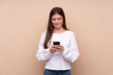 Tecrit edilmiş genç bir kız cep telefonuyla mesaj gönderiyor.