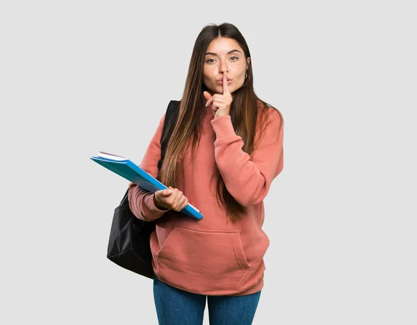 Joven Estudiante Sosteniendo Cuadernos Mostrando Gesto Silencio Poniendo Dedo Boca —  Fotos de Stock