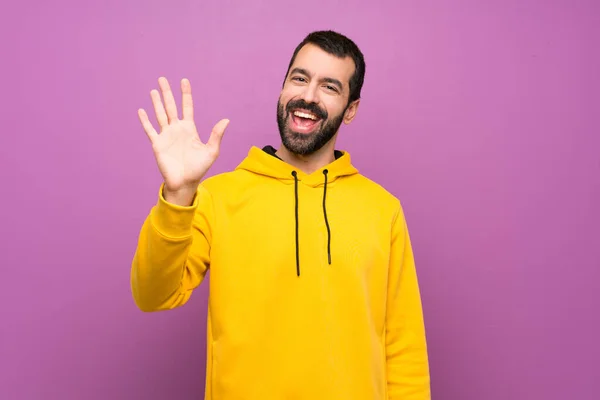 Handsome Man Yellow Sweatshirt Saluting Hand Happy Expression — 图库照片