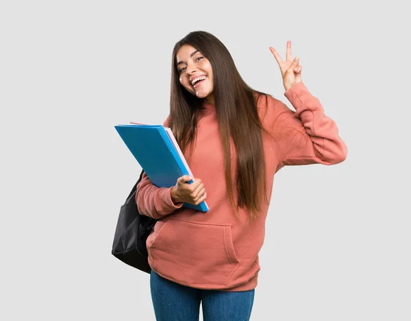 Joven Estudiante Sosteniendo Cuadernos Mostrando Signo Victoria Con Ambas Manos —  Fotos de Stock